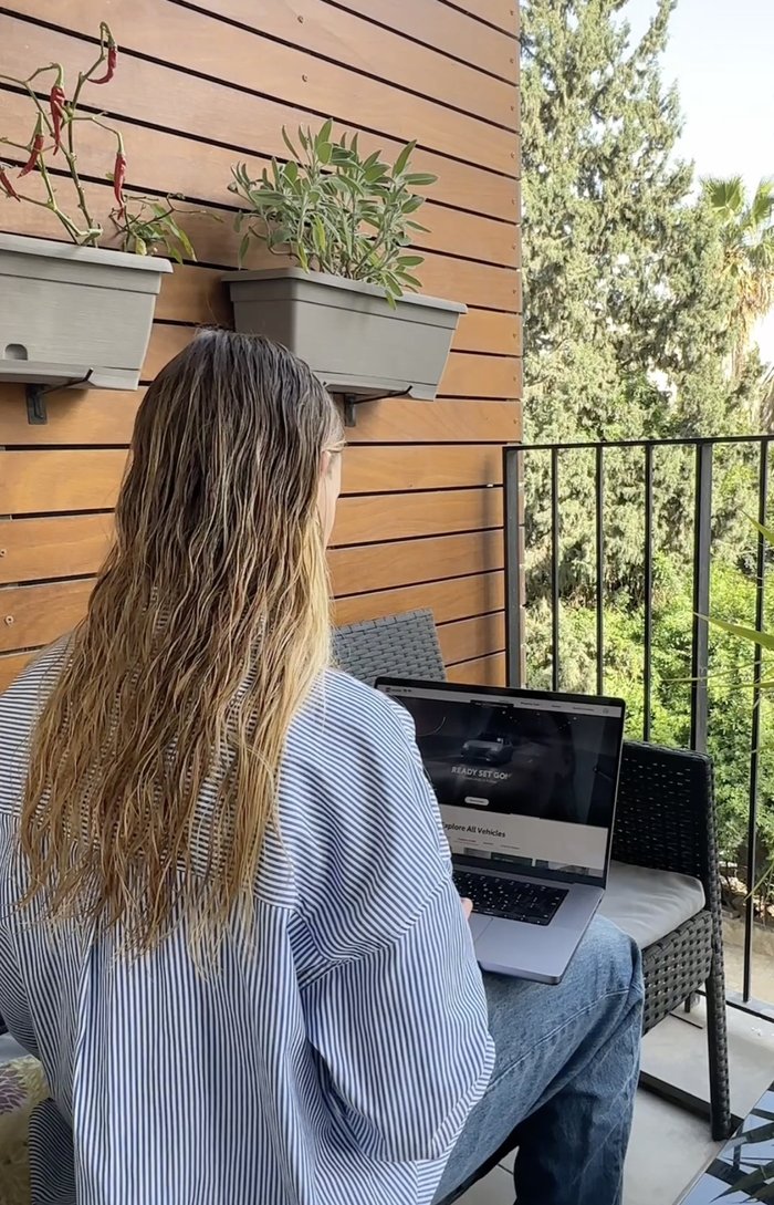 Yulia working on a laptop on her balcony