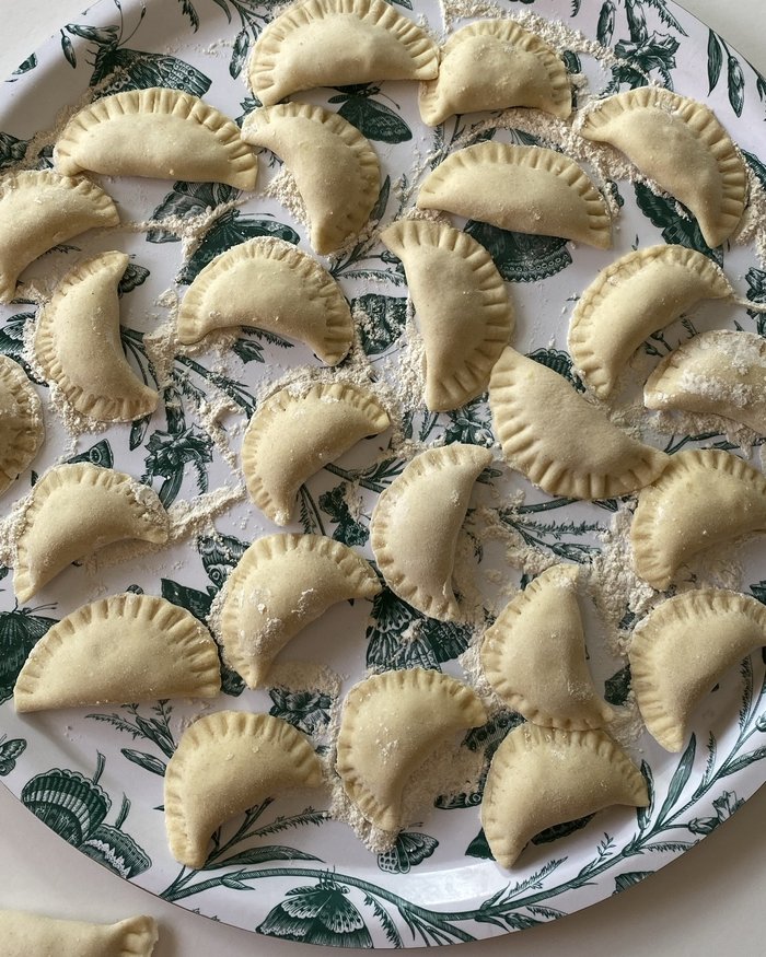 Homemade vareniki, a traditional Russian dish, on a floral plate